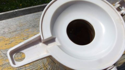 Dank Edelstahlseife riechen muffige Thermoskannen wieder frisch! Eine Thermoskanne mit Edelstahlseife wird verwendet, um unerwünschte Gerüche zu beseitigen. Sie steht auf einer Holzoberfläche.