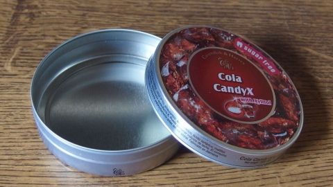 Teigreste: Der perfekte kleine Minikuchen, in einer Bonbondosen aus Aluminum gebacken, wenn eine kleine Form fehlt. Eine geöffnete Metalldose steht auf einem Holztisch, in der sich kein Inhalt befindet, während der Deckel daneben liegt.
