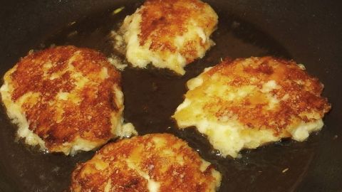 In einer Pfanne braten vier goldbraune Kartoffelpuffer, die für eine zünftige Hauptspeise mit Quark vorgesehen sind.