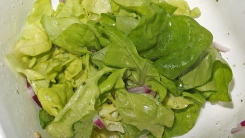 Frischer Blattsalat liegt in einer Schüssel, bereit für weniger Öl am Salat, um gesunde Ernährungsentscheidungen zu treffen.