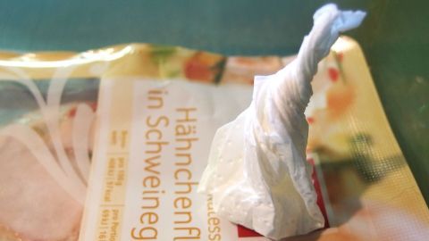 Bewahrt man Wurst oder Käse in Aufschnittdosen auf, kommt es unvermeidbar zu Schwitzwasser, das vom Deckel auf die Lebensmittel tropft. Salz in einem Stückchen Küchenpapier verhindert das. Eine kleine, feuchte Papierserviette steht auf einer Verpackung für Aufschnitt. Sweat in Kühlschrank-Aufschnittdosen vermeiden wird thematisiert.