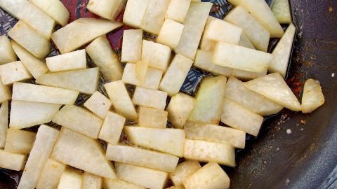 Kohlrabi-Stücke werden in einer Pfanne gebraten, um ein schnelles, leckeres Gemüsegericht zuzubereiten.