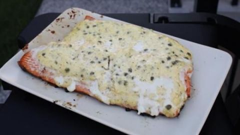 Lachsfilet mit Zitronen-Dill-Mayonnaise und Kapern auf einem Teller, frisch gegrillt im Garten serviert.