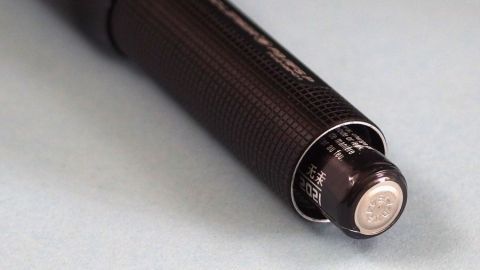 Eine Taschenlampe mit einer festsitzenden Batterie wird auf einem hellen Hintergrund gezeigt, der die Situation verdeutlicht.