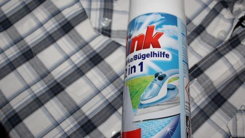 Bügelhilfe: Das gibt es bei Schlecker, Edeka und Co. Ist auch nicht teuer. Ein Bügelhilfe-Spray steht neben einem karierten Hemd und zeigt die Verwendung zur schnellen und einfachen Bügeln.