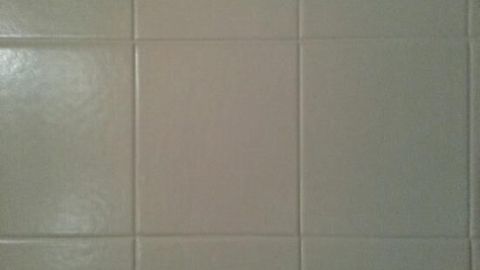 Fliesen an einer Wand im Badezimmer zeigen einen gleichmäßigen, hellen Farbton ohne sichtbare Mängel oder Verschmutzungen.