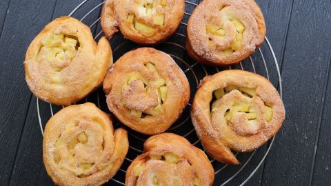 Köstliche Apfelstuten liegen auf einem Gitter, dampfend frisch und mit Zimt-Zucker bestreut.