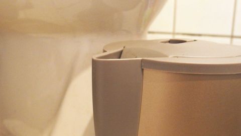 Warmes Essigwasser vom Entkalken des Wasserkochers in der Toilette zum Reinigen weiterverwenden und hartnäckigen Urinstein damit lösen. Ein Wasserkocher steht neben einer Toilette, beide werden gleichzeitig entkalkt, sichtbar in einem Badezimmer.