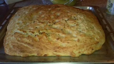 Kartoffelbrot liegt goldbraun gebacken auf einem Blech in einer Küche, bereit zum Abkühlen oder Servieren.
