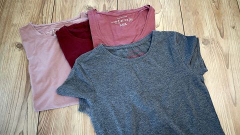 Bunte Shirts liegen auf einem hellen Holzboden, bereit zum Verzieren für individuelle Designs und kreative Projekte.