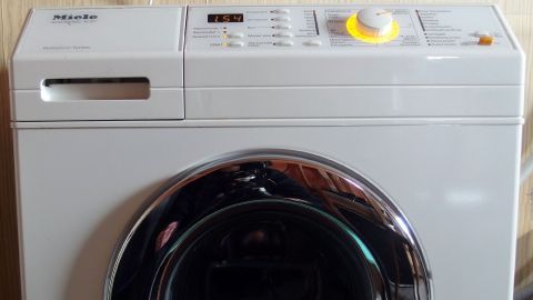 Die Waschmaschine steht bereit, um Wäsche zu waschen, und zeigt verschiedene Programme im Wohnbereich an.