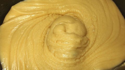 Ein cremiger, fettarmer Rührteig wird in einer Schüssel sorgfältig vermischt, um eine glatte Konsistenz zu erreichen.