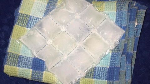 Ein Eiswürfelpack liegt auf einer karierten Decke, ideal zum Kühlen von Hämorrhoiden zur Linderung von Beschwerden.