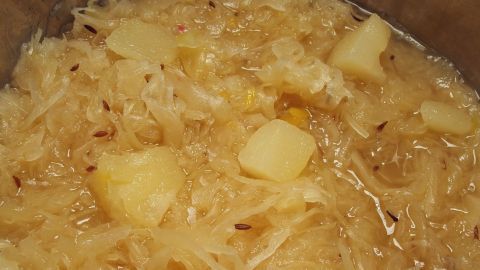 Zarte Stücke von Sauerkraut mit Ananas kochen in einem Topf. Der Duft erfüllt die Küche und sorgt für Vorfreude.