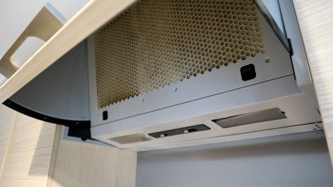 Eine Edelstahldunstabzugshaube ist geöffnet, um gereinigt und versiegelt zu werden, in einer modernen Küchenumgebung.