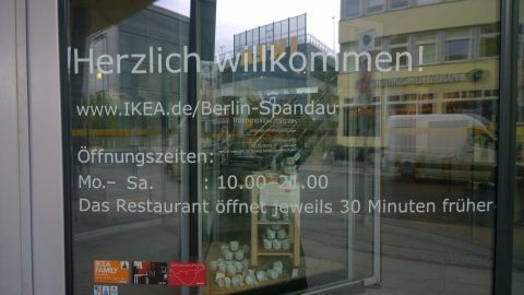 Ein Willkommensschild an der Eingangstür von Ikea zeigt Öffnungszeiten und Informationen über das Restaurant beim Frühstücken.