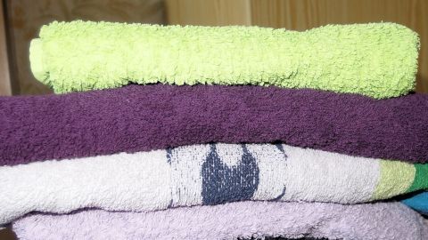 Zur Abwechslung mal pro: Weichspüler Lenor Knitterschutz. Gestapelte Handtücher in verschiedenen Farben liegen ordentlich übereinander und zeigen, wie Weichspüler für Weichheit sorgt.