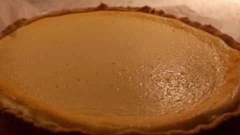Ein goldbrauner Allgäuer Käsekuchen liegt frisch gebacken auf einem Backblech in einer warm beleuchteten Küche.