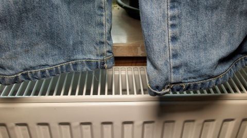 Kleine Bude und kein Platz zum Wäsche trocknen? Es geht supereinfach. Der Tipp zeigt dir wie. Eine Jeans hängt über einen Heizkörper, um in der kleinen Bude schnell zu trocknen, da kein Platz zum Wäsche trocknen ist.
