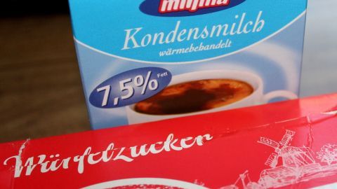 Kondensmilch und Würfelzucker stehen in einer Küche bereit, um gegen den Hustenreiz verwendet zu werden.