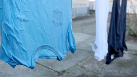 Bunte Wäsche hängt im Freien an einer Leine und sieht knittrig aus, bereit, möglicherweise durch Wind geglättet zu werden.