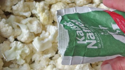 Weißer Blumenkohl wird mit einem Paket Gewürz gesprenkelt, um die Garung zu verbessern und den Geruch zu reduzieren.