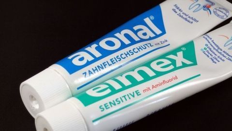 Zwei Zahnpasten stehen nebeneinander auf einem schwarzen Hintergrund, um Zahnprovisorien zu schützen und Empfindlichkeit zu lindern.