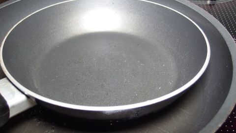 Eine Pfanne liegt sauber auf einem Kochfeld, bereit für die Reinigung mit Soda, um mögliche Rückstände zu entfernen.