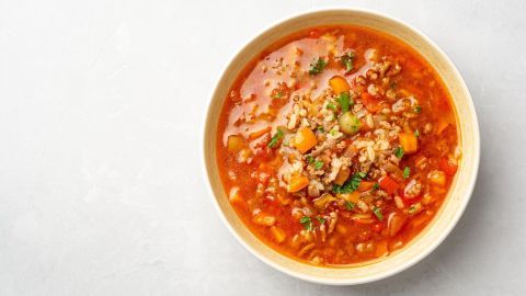 Eine herzliche Reitersuppe aus Hackfleisch und Ananas in einer bunten Gemüsesuppe mit Reis in einer Schüssel.