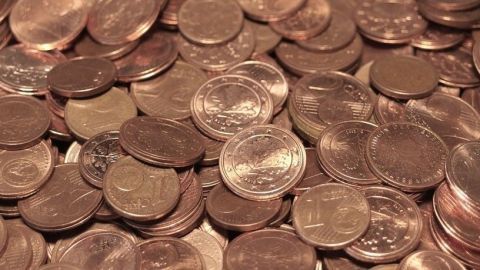 Eine Vielzahl von Cent-Münzen liegt verstreut auf einer Oberfläche, die Fragen zu Kleingeld und dessen Aufbewahrung aufwirft.