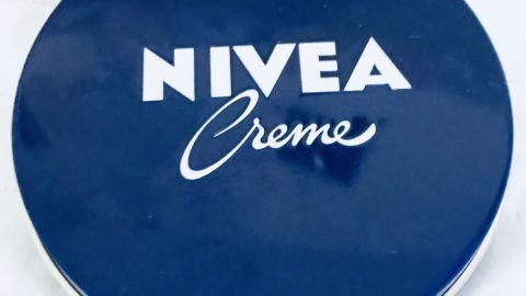 Eine Nivea-Creme-Dose liegt auf einem hellen Untergrund und präsentiert sich in einem klassischen, blauen Design.