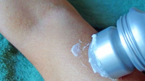 Mit diesem Tipp können sich Kleinkinder prima selber eincremen. Ein Arm ist mit Sonnencreme eingerieben. Ein behutsames Eincremen findet auf einer weichen, grünen Unterlage statt.
