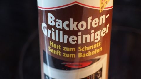 Ein Flasche Backofen-Grillreiniger steht vor dunklem Hintergrund und betont seine Reinigungswirkung gegen hartnäckigen Schmutz.