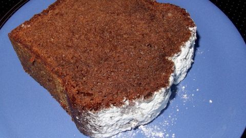 1 EL Apfelessig zum Teig hinzufügen und der Schokoladenkuchen wird viel saftiger und schmeckt lecker! Ein saftiges Stück Schokoladenkuchen liegt auf einem blauen Teller, umgeben von einem schlichten Hintergrund.