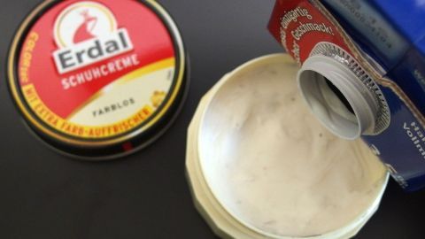 Mit einem Tropfen Milch wird eingetrocknete Schuhcreme wieder weich. Eine runde Dose mit Erdal Schuhcreme und ein offener Behälter, der die trockene Creme zeigt, um sie mit Milch zu revitalisieren.