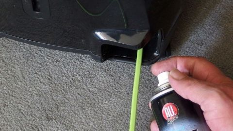 Staubsaugerkabel rollt sich nicht mehr richtig auf? Einfach das Kabel mit Cockpitspray fürs Auto einsprühen und das Kabel flutscht wie von selbst zurück. Ein Handwerker sprüht Pflegeprodukt in das Kabelaufroller eines Staubsaugers, um die Funktion zu verbessern.