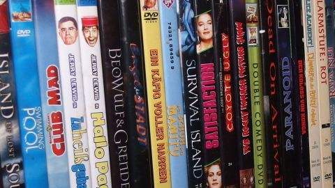 Eine Sammlung von DVDs steht auf einem Regal, bereit für einen Tausch. Genres und Titel sind vielfältig, von Filmen bis Musik.
