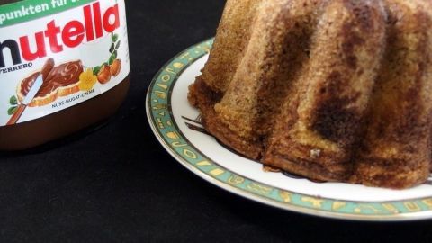 Für Nutella-Junkies: Nutella statt Kakao für den Marmorkuchen nehmen. Ein Marmorkuchen steht auf einem Teller neben einem Glas Nutella, bereit, von Nutella-Junkies genossen zu werden.