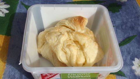 Ein günstiger Plastikbehälter beherbergt einen Teigklumpen auf einem bunten Tuch, ideal zum Backen oder Lagern.