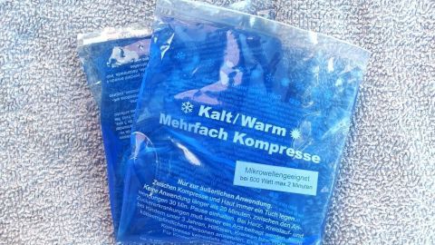 Kalte und warme Gel-Pads liegen verpackt auf einer weichen Oberfläche, bereit zur Verwendung bei Kindern zur Linderung von Beschwerden.