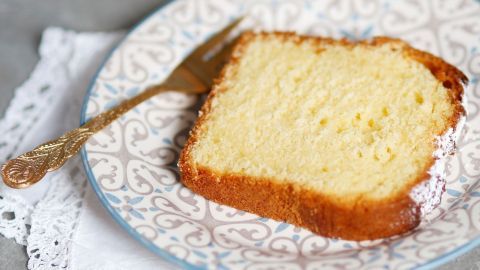 Ein saftiges Stück Eierlikörkuchen liegt auf einem dekorativen Teller mit einer Gabel daneben, umgeben von einem Servietten-Papier.