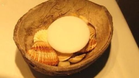 Seife liegt auf Muscheln in einer Schale, verhindert Schmierrückstände, platziert auf einem Waschbeckenrand.