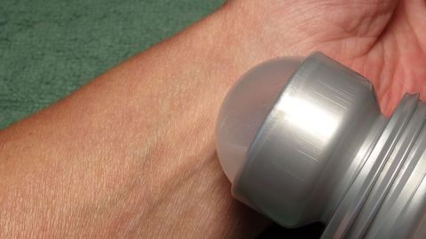Mückenstich: Das sogenannte Antitranspirant mit Aluminiumsalzen als Wirkstoff, lässt die Schwellung und den Juckreiz schnell verschwinden. Ein Deoroller wird auf einen Mückenstich auf einem Handgelenk angewendet, um Linderung zu verschaffen.