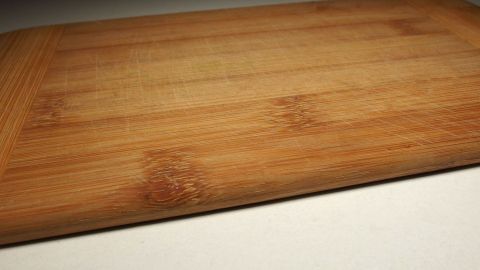 Ein verzogenes Holzbrett liegt schief auf einer Oberfläche und benötigt eine Korrektur, um wieder gerade zu sein.