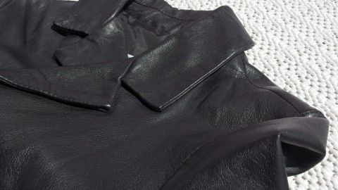 Wer einen speckigen Lederjackenkragen an seine Lederjacke hat, muss nicht verzweifeln: Ein supereinfacher Reinigungstipp! Ein speckiger Lederjackenkragen liegt auf einem hellen Untergrund, bereit, mit einem Erfrischungstuch gereinigt zu werden.