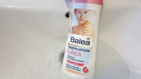 Bodylotion: So hat man ein schönes pflegendes Duftbad und eine angenehme Resteverwertung. Ein Flakon mit Balea Bodylotion hängt unter einem Wasserhahn und wird von Wasser umgeben, was eine frische Anwendung symbolisiert.