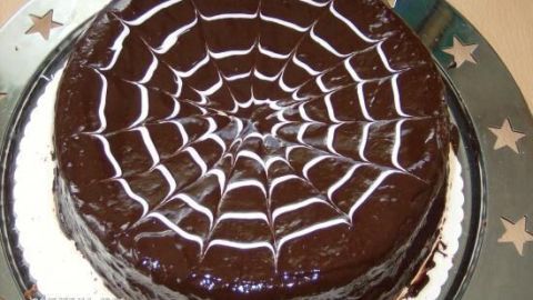 Sachertorte mit Schokoladenglasur zeigt ein Spinnwebenmuster auf einem silbernen Teller mit Sternen am Rand. Datum: 2010/09/14.