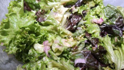 Frischer Blattsalat gemischt mit einer cremigen Salatsoße, die ihm Geschmack und Farbe verleiht.