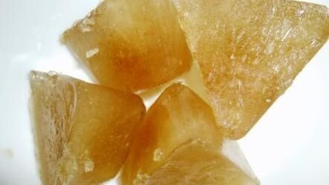 Braune Eisbonbons liegen in einer Schale, bereitgestellt für die Linderung von Halsschmerzen.
