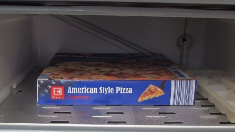 Eine tiefgekühlte American Style Pizza liegt im Eisfach, um frisch zu bleiben und für die Zubereitung bereit zu sein.